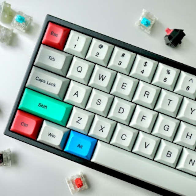 Keyboard with white, green, red, and blue keys. Image by Jay Zhang via Unsplash.